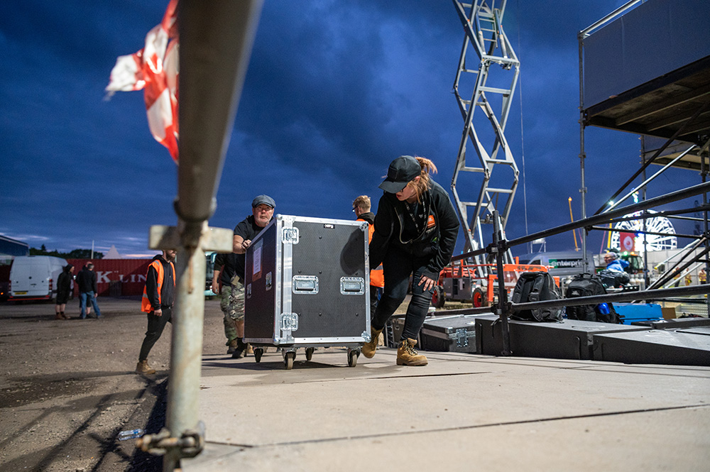 Backstage crew pushing a flight case.